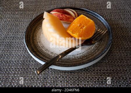 Three fruits in a beautiful dark earthenware dish Placed on a mat on the dining table As a dessert after a meal Stock Photo