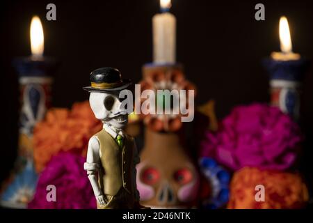 Closeup shot of plastic skulls figurine with a hat for an offering of the day of the dead Stock Photo