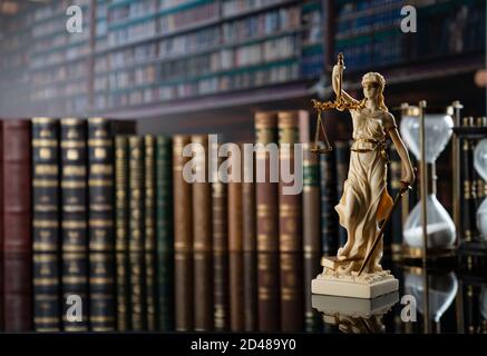 Law and justice concept. Gavel of the jugde, Themis sculpture and scale of justice in the court library. Stock Photo