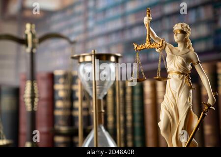 Law and justice concept. Gavel of the jugde, Themis sculpture and scale of justice in the court library. Stock Photo