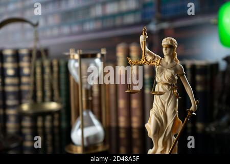 Law and justice concept. Gavel of the jugde, Themis sculpture and scale of justice in the court library. Stock Photo