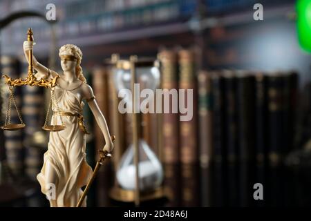 Law and justice concept. Gavel of the jugde, Themis sculpture and scale of justice in the court library. Stock Photo