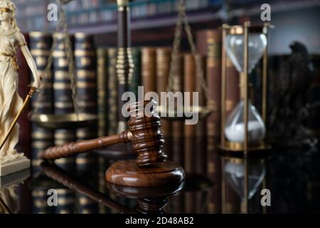 Law and justice concept. Gavel of the jugde, Themis sculpture and scale of justice in the court library. Stock Photo