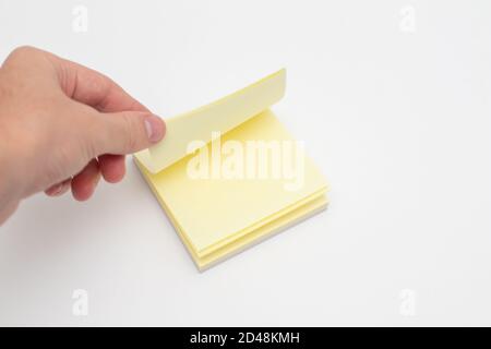 Hand takes a sticker from a stack of colored stickers Stock Photo