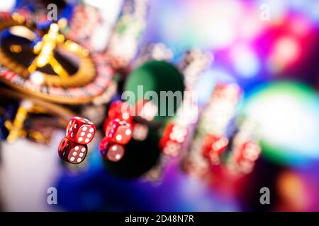 Casino concept.  Roulette wheel, poker chips and dice on shining table and on  colorful bokeh background. Stock Photo
