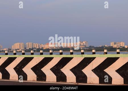 Landscape photography A spectacular view of large modern buildings from the road passing through the bridge over the lake of water in the morning Stock Photo