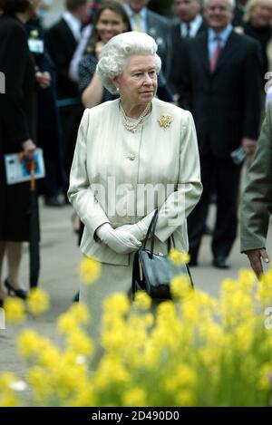 Britain's Queen Elizabeth II examines exhibits during her visit to the Royal Horticultural Society's Chelsea Flower Show in London May 19, 2003. Thousands of visitors are expected to attend the 81st annual show, organised by the Royal Horticultural Society and held at the Royal Hospital in Chelsea, west London. REUTERS/Stephen Hird  SH/NMB