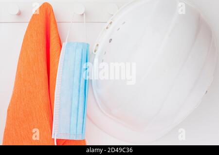 Protective workwear including face mask because of covid-19 and high visilibity vest Stock Photo