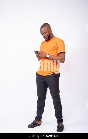handsome young black man using his smartphone, texting and chatting online concept on social media, browsing Stock Photo