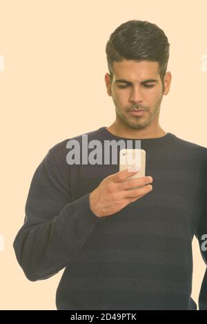 Young handsome Persian man using mobile phone Stock Photo