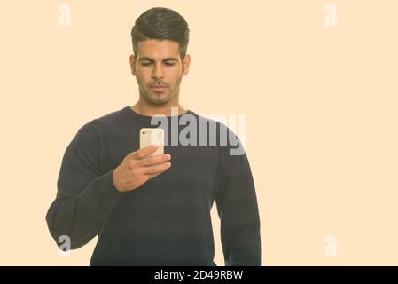 Young handsome Persian man using mobile phone Stock Photo