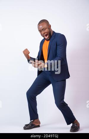 excited young black businessman celebrating while looking at his phone Stock Photo