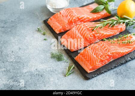 Salmon. Fresh raw salmon fish fillet with cooking ingredients, herbs and lemon. Close up. healthy food, diet or cooking concept Stock Photo