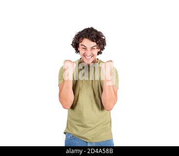 Pleased young man, long curly hair style, celebrates success hysterical and passionate. Guy keeps fists tight, screaming, isolated over white backgrou Stock Photo