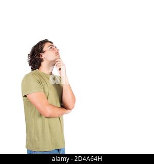 Side view portrait of pensive young man, long curly hair style, keeps hand under chin, looking up thoughtful gesture, isolated over white background w Stock Photo