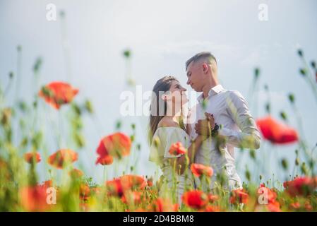 Young woman and man in love walking embracing on field, valentines day. Stock Photo