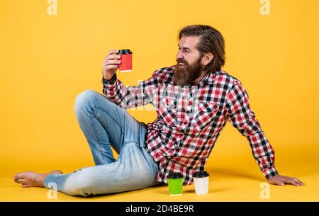 nice taste. good morning. energetic warm take away beverage. need some coffee to go for inspiration. happy bearded man drinking morning coffee. man drink hot tea from paper cup. Stock Photo