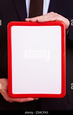 Hands holding an small empty whiteboard with red frame Stock Photo