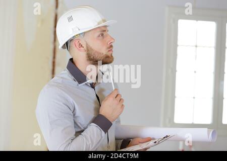 young builder thinking about something Stock Photo