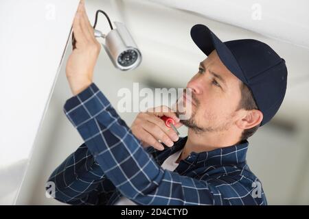 man installs a surveillance camera Stock Photo