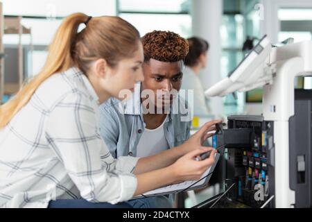 female and male technician fixing a printer Stock Photo