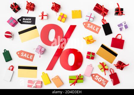 Top view of percent sign with credit cards and toy shopping bags on white background Stock Photo