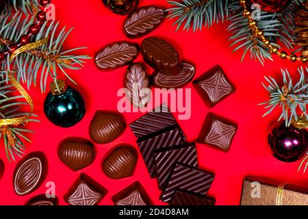 Chocolates on a red background. New Year's 2021 decor and chocolate, candy - festive photo for confectionery. Stock Photo