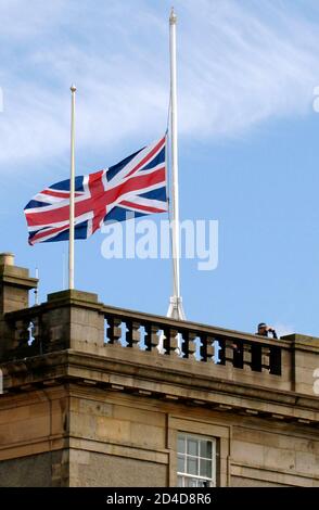 A policeman looks through binoculars next to a British flag flying at half-mast at the G8 summit in Gleneagles, Scotland, July 7, 2005. Four blasts ripped through London during rush hour on Thursday morning, killing at least 33 people and disrupting a summit of Group of Eight leaders in Scotland in attacks Prime Minister Tony Blair branded as 'barbaric.' REUTERS/Julia Fassbender/Pool  CRB/TC