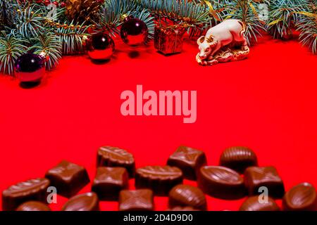Chocolates on a red background wits bull. New Year's 2021 decor and chocolate, candy - festive photo for confectionery with place for text Stock Photo