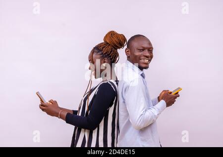 two young male and female hipsters using mobile phone with excitement browsing online news Stock Photo