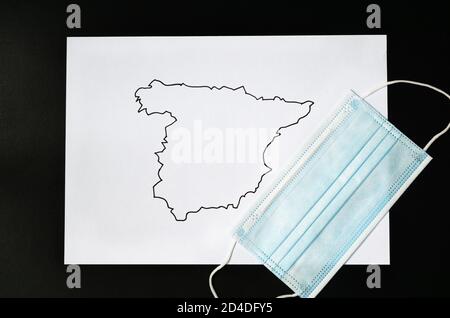 Map of spain drawn on a white sheet with a covid-19 mask coronavirus Stock Photo
