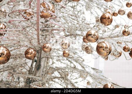 Gold glossy Christmas balls on a white glass Christmas tree. Stock Photo
