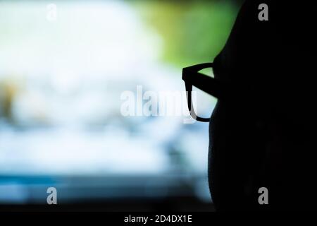 Man Using Magnifying Glasses for Watching TV Stock Photo