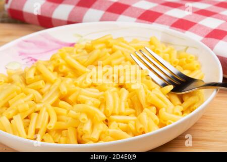 Plate full of delicious Macaroni and cheese on a wooden background Stock Photo
