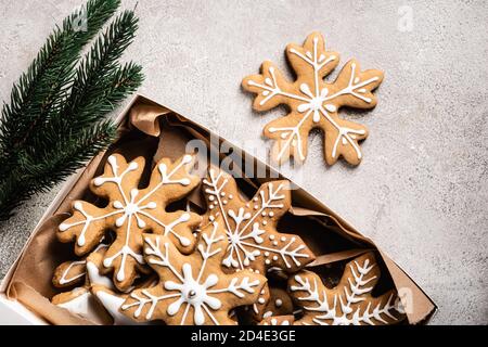 Top view of box of gingerbread cookies near brunch of pine on grey background Stock Photo