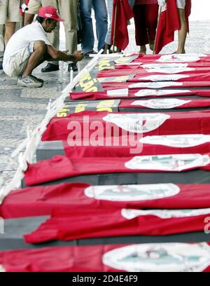 A member of Brazil's Landless Movement (MST) lights a candle next to coffins during a demonstration in Rio de Janeiro April 16, 2004, marking the eighth anniversary of a police massacre of 19 rural workers. Landless workers, trade unions and Roman Catholic Church groups have called for a day of protests to remember those killed in the 1996 massacre in which police opened fire on farmers demanding land in the remote in Eldorado dos Carajas, Northeastern Brazil. REUTERS/Sergio Moraes  SM/HB