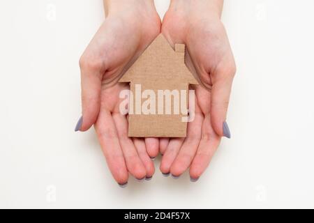 Paper house in female hands. Family home concept Stock Photo