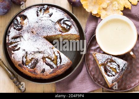 Plum pie with nuts and chocolate on a wooden background. Rustic style. Stock Photo