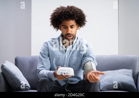 African Patient Doing Blood Pressure Check At Home Stock Photo