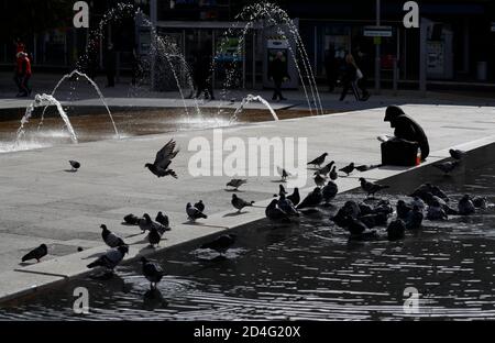 Nottingham, Nottinghamshire, UK. 9th October 2020. A man reads a newspaper in the Market Square after it was announced Nottingham has the highest Covid-19 infection rate in the UK. Credit Darren Staples/Alamy Live News. Stock Photo