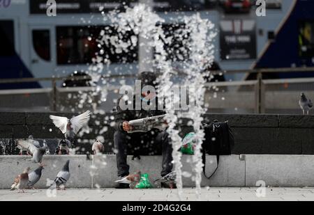 Nottingham, Nottinghamshire, UK. 9th October 2020. A man reads a newspaper in the Market Square after it was announced Nottingham has the highest Covid-19 infection rate in the UK. Credit Darren Staples/Alamy Live News. Stock Photo