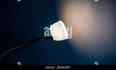 Lamp illuminated black wall in a room, space for text or ideas Stock Photo