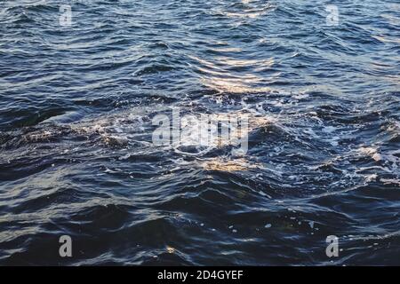Sun reflects in blue wavy water. Sea water background Stock Photo