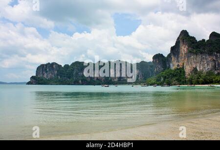 Steep limestone cliffs rising high above the water at Railay West Beach in Krabi Province, Thailand Stock Photo