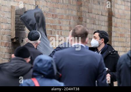 Halle, Germany. 09th Oct, 2020. A plaque is unveiled in front of the synagogue. One year after the right-wing terrorist attack on the highest Jewish holiday Yom Kippur, the victims are remembered with events and prayers. On 9 October 2019, a heavily armed right-wing extremist had tried to storm the synagogue and cause a massacre among 52 visitors. Credit: dpa picture alliance/Alamy Live News Stock Photo