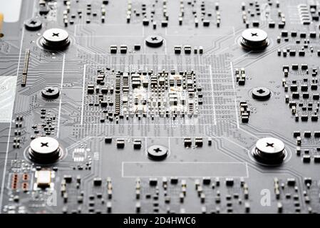 Electronic PCB printed circuit board in macro close-up with transistors circuitry and electric hardware elements, visible computer chips Stock Photo