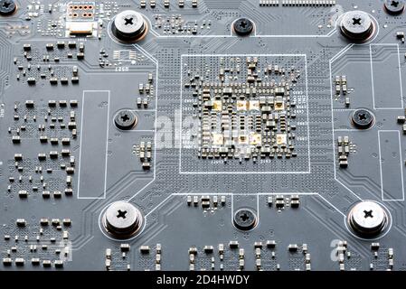 Electronic PCB printed circuit board in macro close-up with transistors circuitry and electric hardware elements, visible computer chips Stock Photo
