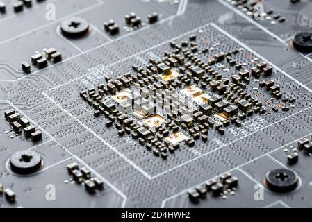 Electronic PCB printed circuit board in macro close-up with transistors circuitry and electric hardware elements, visible computer chips Stock Photo