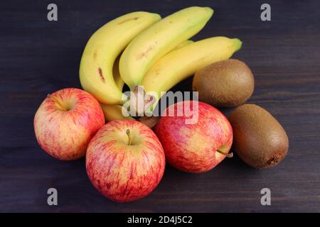 Heap of Fresh Ripe Tasty Fruits on Dark Brown Wooden Background for the Concept of EATING WELL Stock Photo