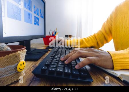 Closeup of a person using the computer on the desk under the lights Stock Photo